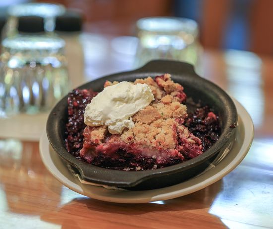 Bowl of berry cobbler topped with vanilla ice cream