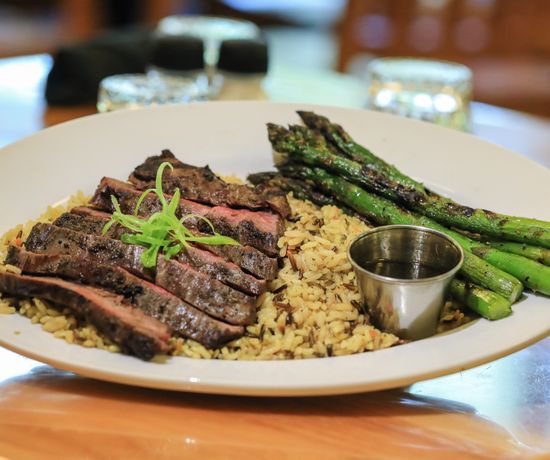 Grilled steak cooking over an open flame.
